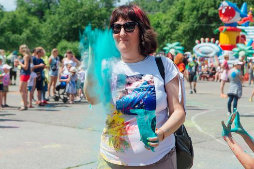 Novokuznetsk, Kemerovo region, Russia - June 12, 2022 :: Woman with colorful face painted with holi powder having fun outdoors.