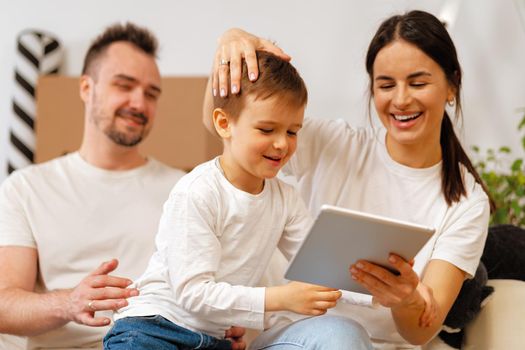 Portrait of happy family with cardboard boxes in new house at moving day, close up