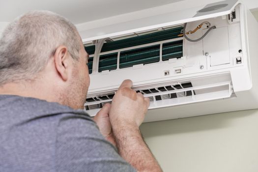 man cleans the air conditioning. air conditioner repair