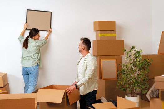 Young happy couple in room with lots of moving boxes at new home