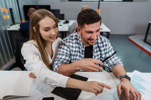 Two entrepreneurs man and woman sitting together working in an office, close up