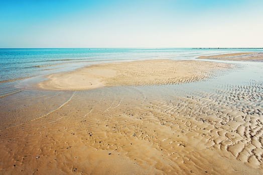 View of the Adriatic Sea from the sandy beach in Pesaro, Italy, during a sunny spring day