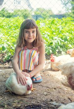 A child on a farm with a chicken. Selective focus.