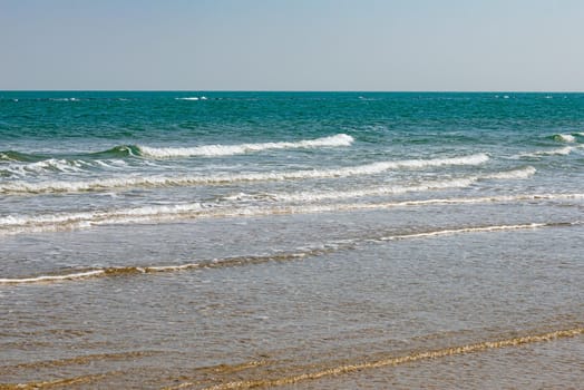 View of the Adriatic Sea from the sandy beach in Pesaro, Italy, during a sunny spring day