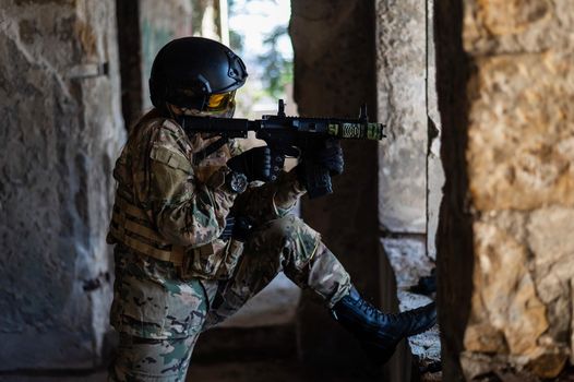 A woman in an army uniform shoots a firearm in an abandoned building