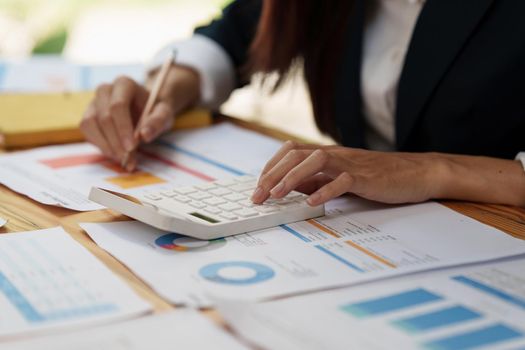 Close up Business woman hand using calculator to calculate the company's financial results and budget. Account Audit Concept