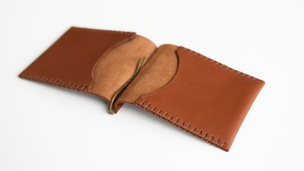 Open empty classics brown leather handmade money clip wallet on white background. Leather accessories