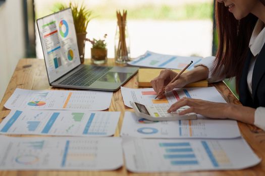 Close up Business woman hand using calculator to calculate the company's financial results and budget. Account Audit Concept