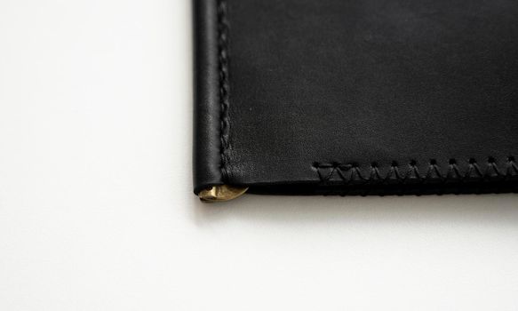 Details of empty classic black leather handmade money clip wallet on white background. Leather accessories