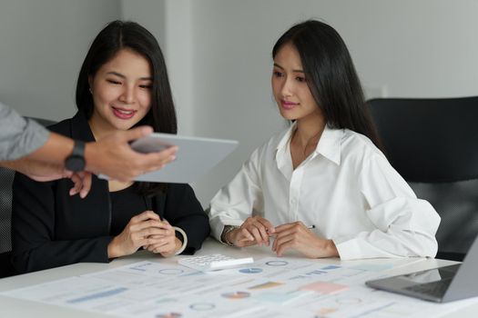 Group of business people working at workplace. Business team hands at working with financial plan, meeting, discussion, brainstorm with tablet on office desk