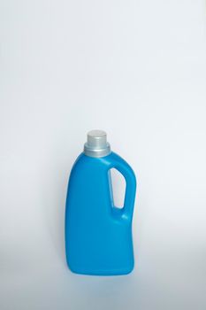 Blue plastic bottle stands on white background. Conditioner or liquid powder for washing. Capacity with space for copying. Layout for logo application