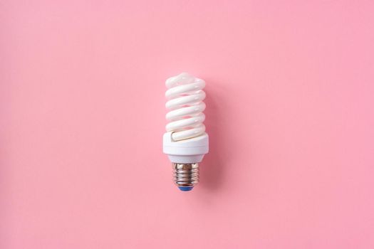 Energy saving light bulb on a pink background. Economical consumption of electricity. The concept of nature conservation