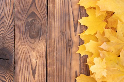Autumn leaves frame on one right side wooden background top view Fall Border yellow and Orange Leaves vintage wood table Copy space. Mock up for your design. Display for product or text