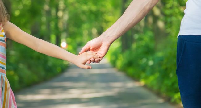 Father and child go holding hand. Selective focus. nature.