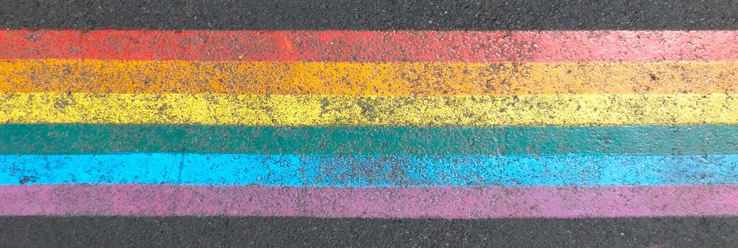 Marked crosswalk with lbgtq pride flag rainbow stripes. Colored chalk