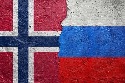 Norway and Russia - Cracked concrete wall painted with a Norwegian flag on the left and a Russian flag on the right