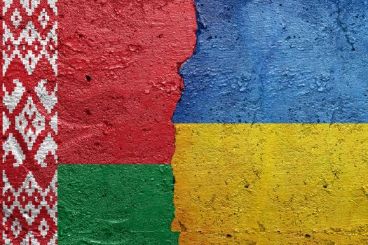 Belarus and Ukraine - Cracked concrete wall painted with a Belarusian flag on the left and a Ukrainian flag on the right