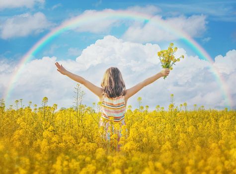 A child in a yellow rainbow field. Selective focus. nature.