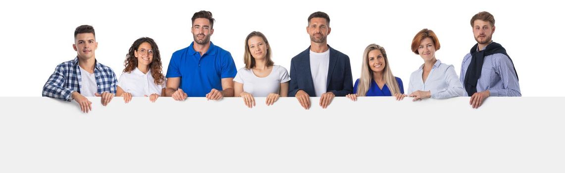 Happy smiling group of friends standing together in a row and displaying a white placard to write it on your own text, isolated on white background