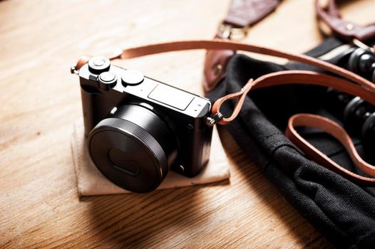 closeup vintage style of digital mirrorless camera with leather strap.