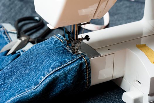 sewing indigo denim jeans with sewing machine, garment industrial concept.