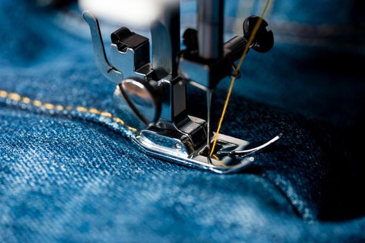 sewing indigo denim jeans with sewing machine, garment industrial concept.