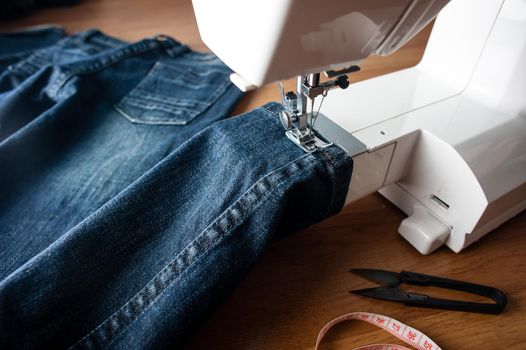 sewing indigo denim jeans with sewing machine, garment industrial concept.