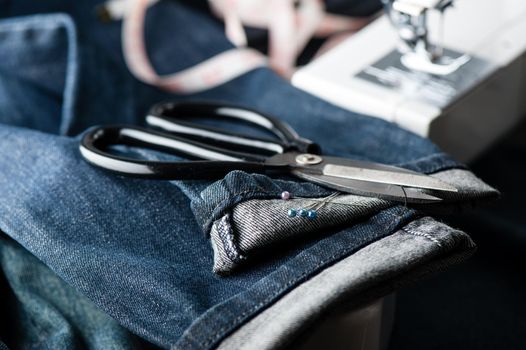 indigo denim fabric with sewing equipments, garment industrial concept.