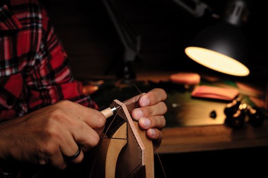 Sewing the vegetable tanned leather by hand. Leather and the craft tools.