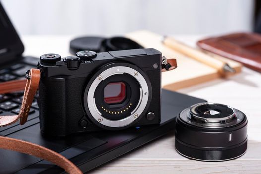 closeup vintage style of digital mirrorless camera with leather strap.