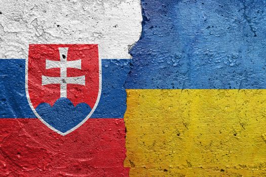 Slovakia and Ukraine - Cracked concrete wall painted with a Slovak flag on the left and a Ukrainian flag on the right