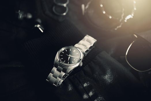 closeup luxury automatic wristwatch for men with black dial and stainless steel bracelet.