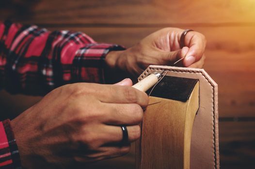 Sewing the vegetable tanned leather by hand. Leather and the craft tools.