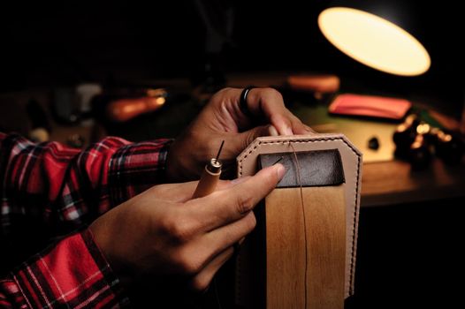 Sewing the vegetable tanned leather by hand. Leather and the craft tools.