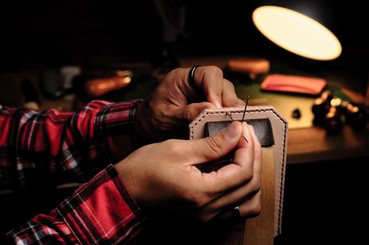 Sewing the vegetable tanned leather by hand. Leather and the craft tools.