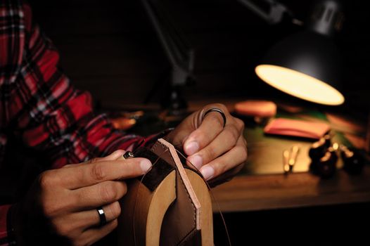 Sewing the vegetable tanned leather by hand. Leather and the craft tools.