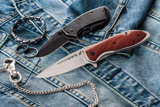 stainless steel folding knife with wooden handle and other everyday carry (EDC) items for men. closeup at folding knife. 