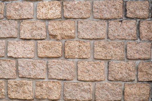 Stone wall texture: brown, orange, terracotta. Stone blocks.  Brown brick wall seamless background.