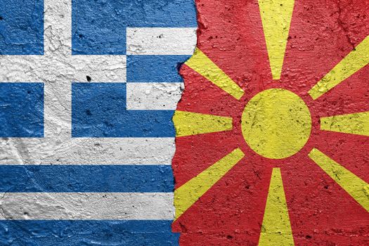 Greece and Northern Macedonia - Cracked concrete wall painted with a Greek flag on the left and a Macedonian flag on the right