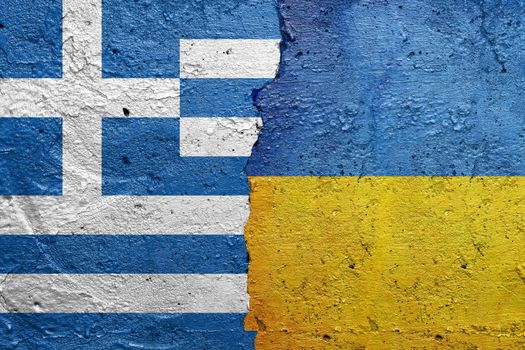 Greece and Ukraine - Cracked concrete wall painted with a Greek flag on the left and a Ukrainian flag on the right