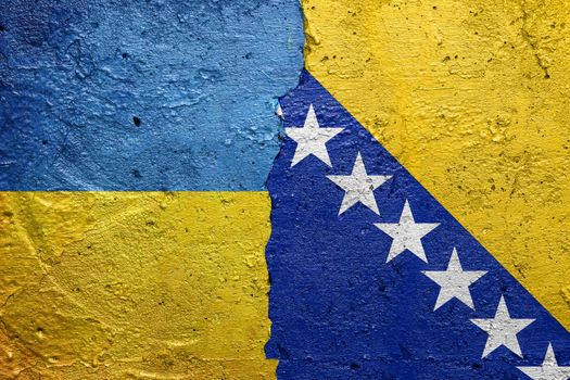 Ukraine and Bosnia and Herzegovina - Cracked concrete wall painted with a Ukrainian flag on the left and a Bosnian flag on the right