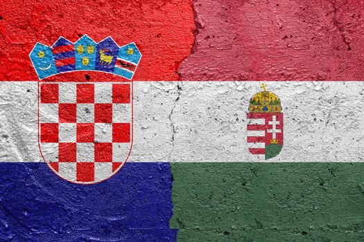 Croatia and Hungary - Cracked concrete wall painted with a Croatian flag on the left and a Hungarian flag on the right