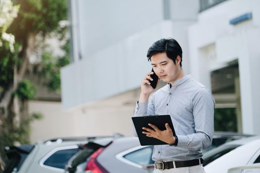 Insurance claim concept, car insurance policy owner talking on the phone with car insurance company holding insurance documents to inform car repair