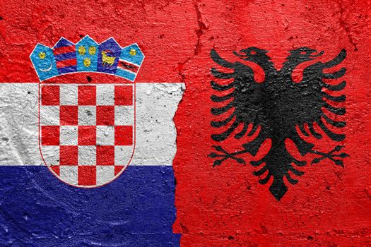 Croatia and Albania - Cracked concrete wall painted with a Croatian flag on the left and a Albanian flag on the right