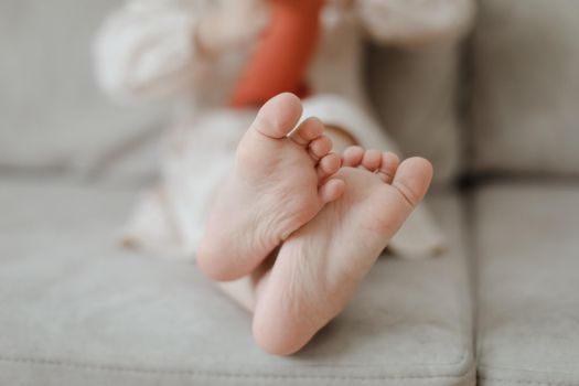 child bare little feet close-up indoors. child sitting barefoot.