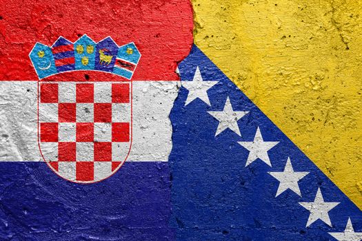 Croatia and Bosnia and Herzegovina - Cracked concrete wall painted with a Croatian flag on the left and a Bosnian flag on the right