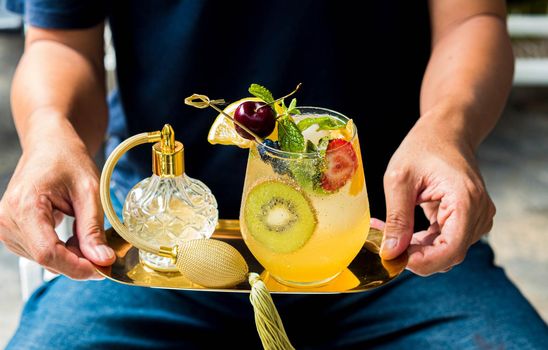 Asian Man Hold glass of mocktail or cocktail. Serving Mocktail Glass mixed fruit non-alchohol cocktail