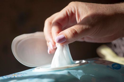 Hand picked a wet wipes in package box, Wet wipes in a woman's hand