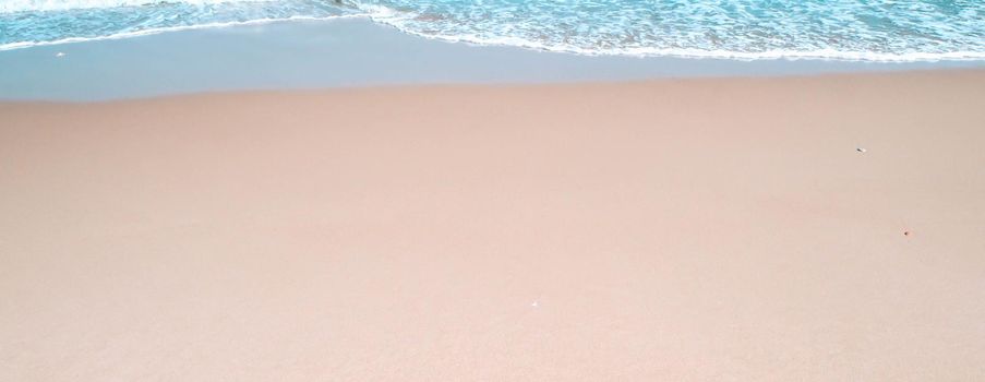 Sand on tropical beach on summer season. Simple beach background for summer. Bubble blue wave from sea to sand on the beach. Summer background.