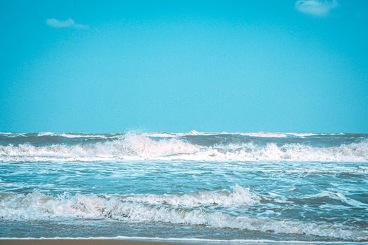 Soft wave with bubble of Blue Ocean on white sand at tropical beach on summer season. Simple beach background for summer. Bubble blue wave from sea to sand on the beach. Summer background.